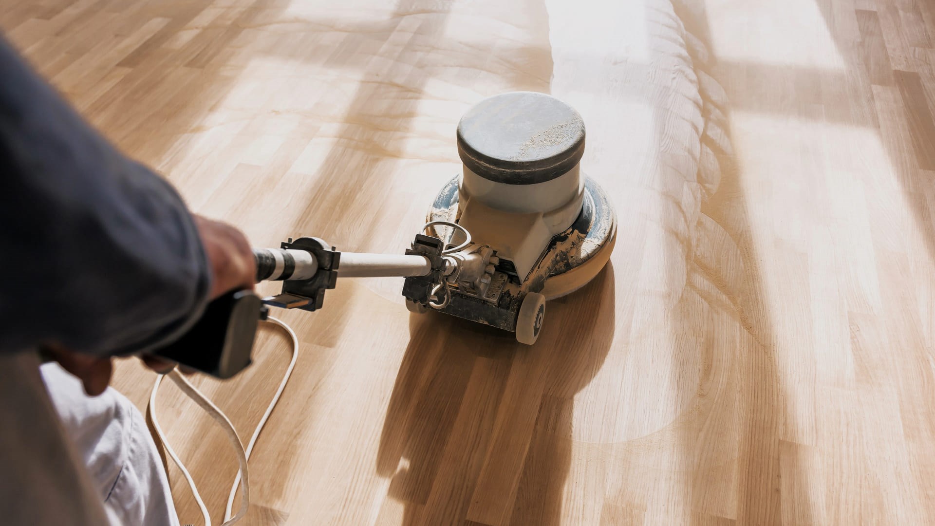 Travail de sablage en cours sur un plancher de bois franc avec une machine professionnelle pour redonner de l’éclat à la surface.